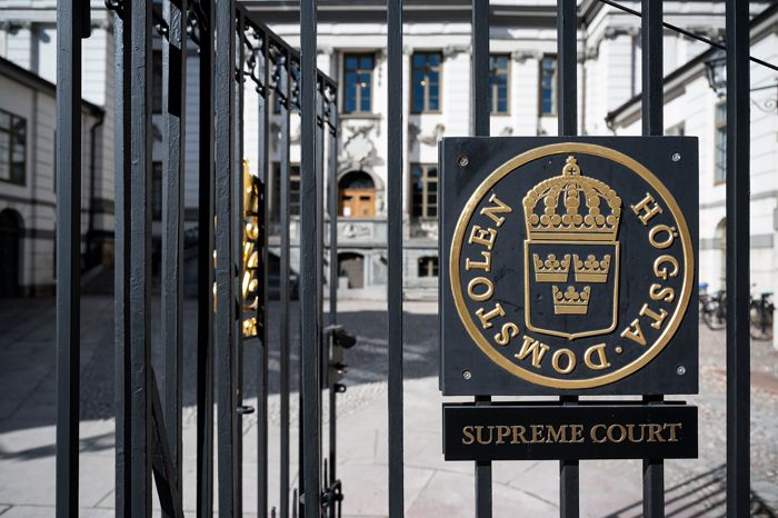 Swedish Supreme Court sign in foreground. Supreme Court building in background