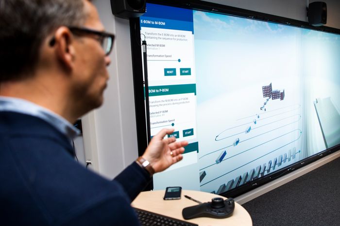 man bakifrån till vänster, skärm med forskningsresultat till vänster.