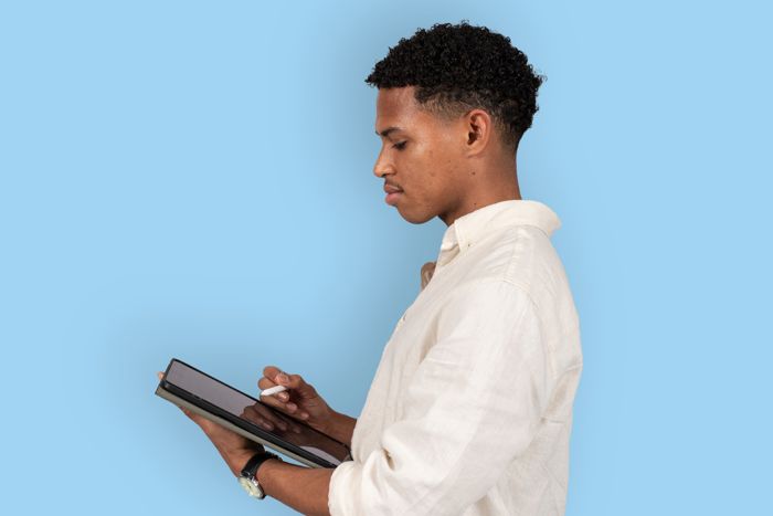 Foto av en person i profil som håller i en surfplatta.