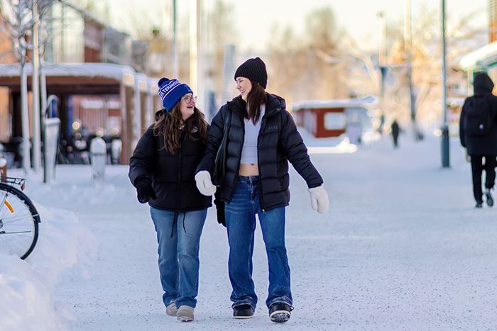 Två personer gåendes utomhus i snöig miljö