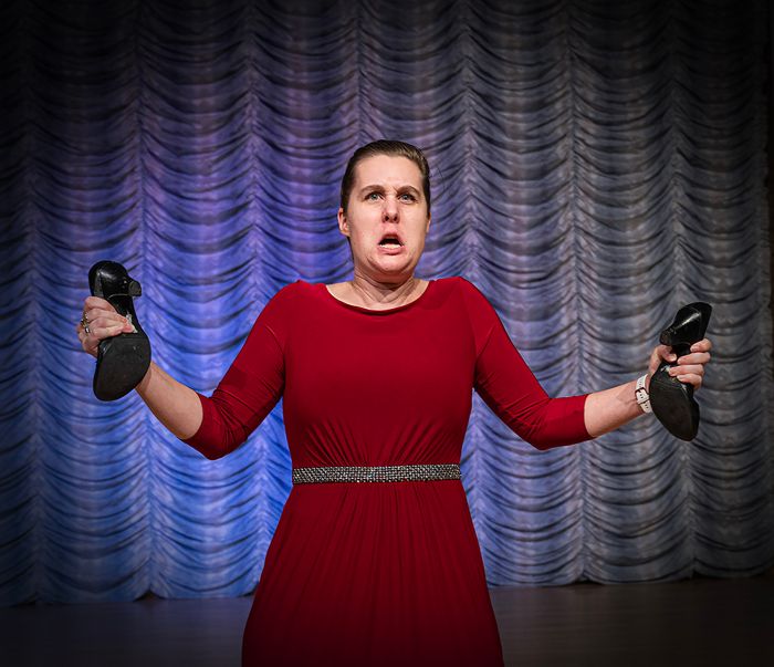 Female opera singer holding a pair of shoes