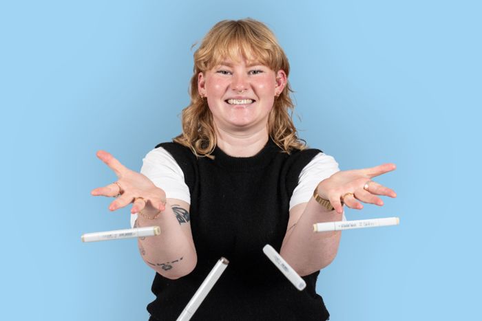 Portätt av en ung kvinna som kassar skisspennor